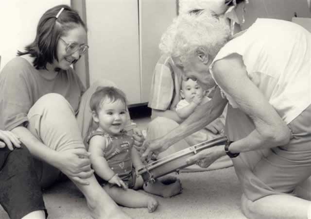 Barbara Cass-Beggs invites a toddler to tap on her drum during a "Your Baby Needs Music" class.