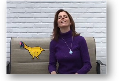 Miss Ellen from the West Hartford Public Library sits on a glider outside her home and uses that as a flannel board by putting a felt bird on it.