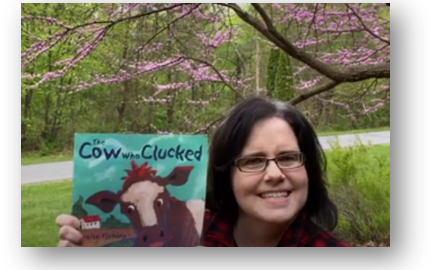 Presenting MGOL from home - a librarian outdoors holding a book