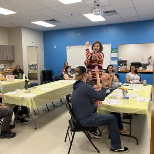 Cecil County Librarian Summer Rosswog uses her hands to demonstrate how learning takes place in the brain, while the parents attending her Hatchlings program make their hands into neurons, too!