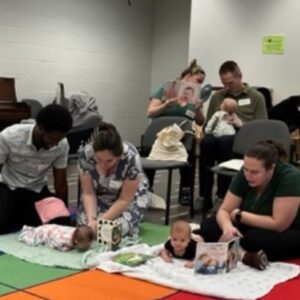 Parents try out Tummy Timmy at a Montgomery County Library Hatchlings’ session.